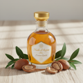 Huile d'Argan Bio dans un flacon en verre entouré de noix d'argan brutes
